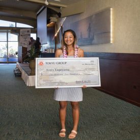 Avery Kageyama holding her scholarship check and smiling