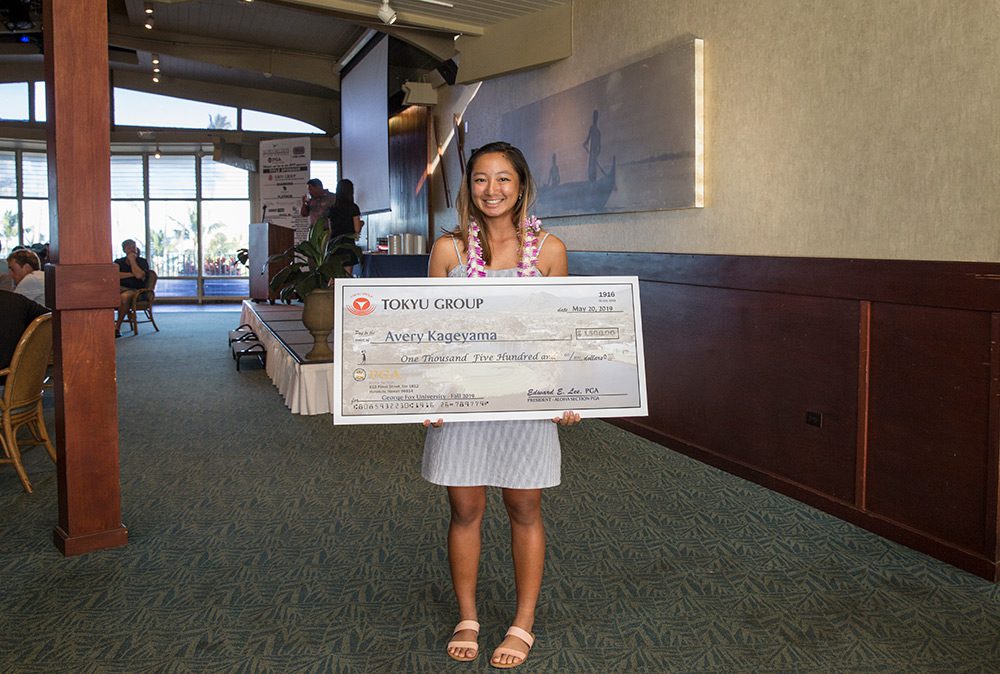 Avery Kageyama holding her scholarship check and smiling